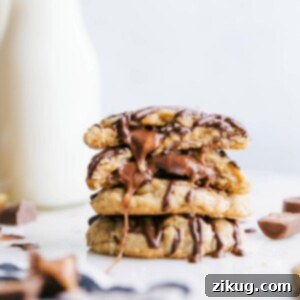 Ready-to-eat caramel oatmeal cookies stacked on top of each other, with one broken in half to reveal the gooey caramel center.