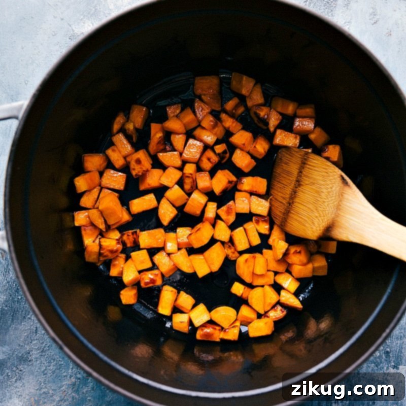 Preparing Sweet Potatoes: Building the Flavor Base for Quinoa Chili Sweet potatoes simmering gently in a large pot with spices, becoming tender and infused with flavor for the Quinoa Chili.