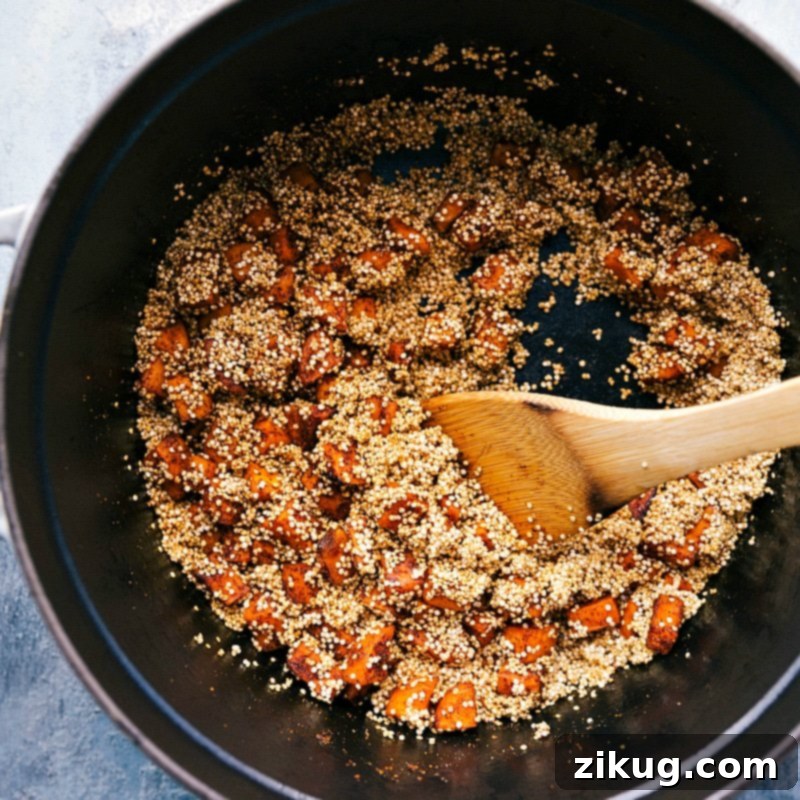 Combining Quinoa and Sweet Potatoes for a Rich Chili Base Raw quinoa being added to a pot, joining the already sautéed sweet potatoes and spices, a key step in preparing the Quinoa Chili.