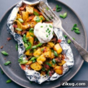 Baked potato foil pack with sour cream and chives, a hearty meal ready to enjoy.