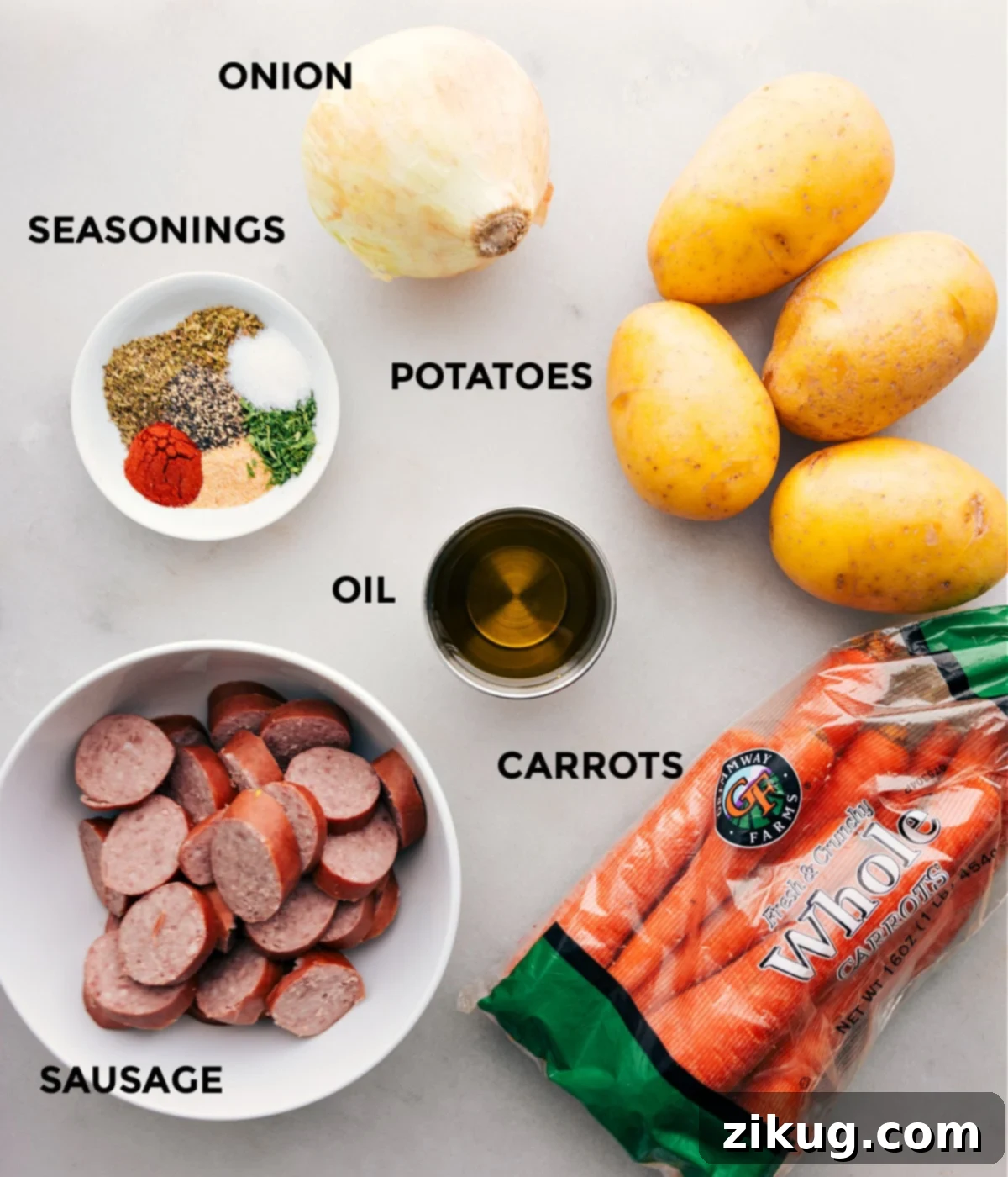 Essential Ingredients for Delicious Hobo Foil Packets All the fresh ingredients including smoked sausage, seasonings, thinly sliced onion, potatoes, and carrots, perfectly prepped and laid out for assembling Hobo Foil Packets.