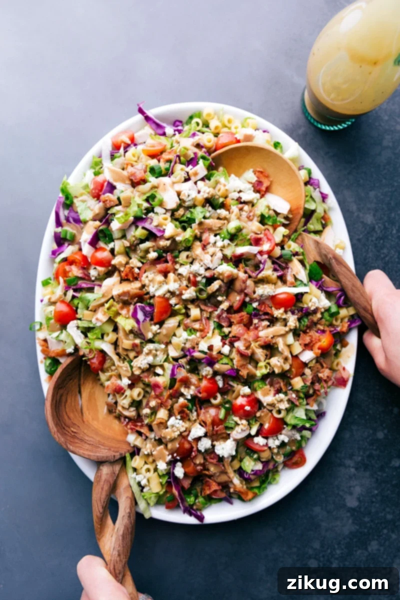 Portillo's Chopped Salad with Serving Spoons A vibrant bowl of Portillo's Chopped Salad with two serving spoons, ready to be enjoyed.