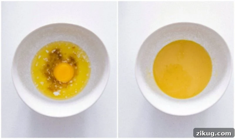 Combining butter, vanilla, and egg yolk for the dough. Process photo showing a bowl with melted butter, an egg yolk, and vanilla extract being whisked together, part of the Homemade Cinnamon Roll preparation.