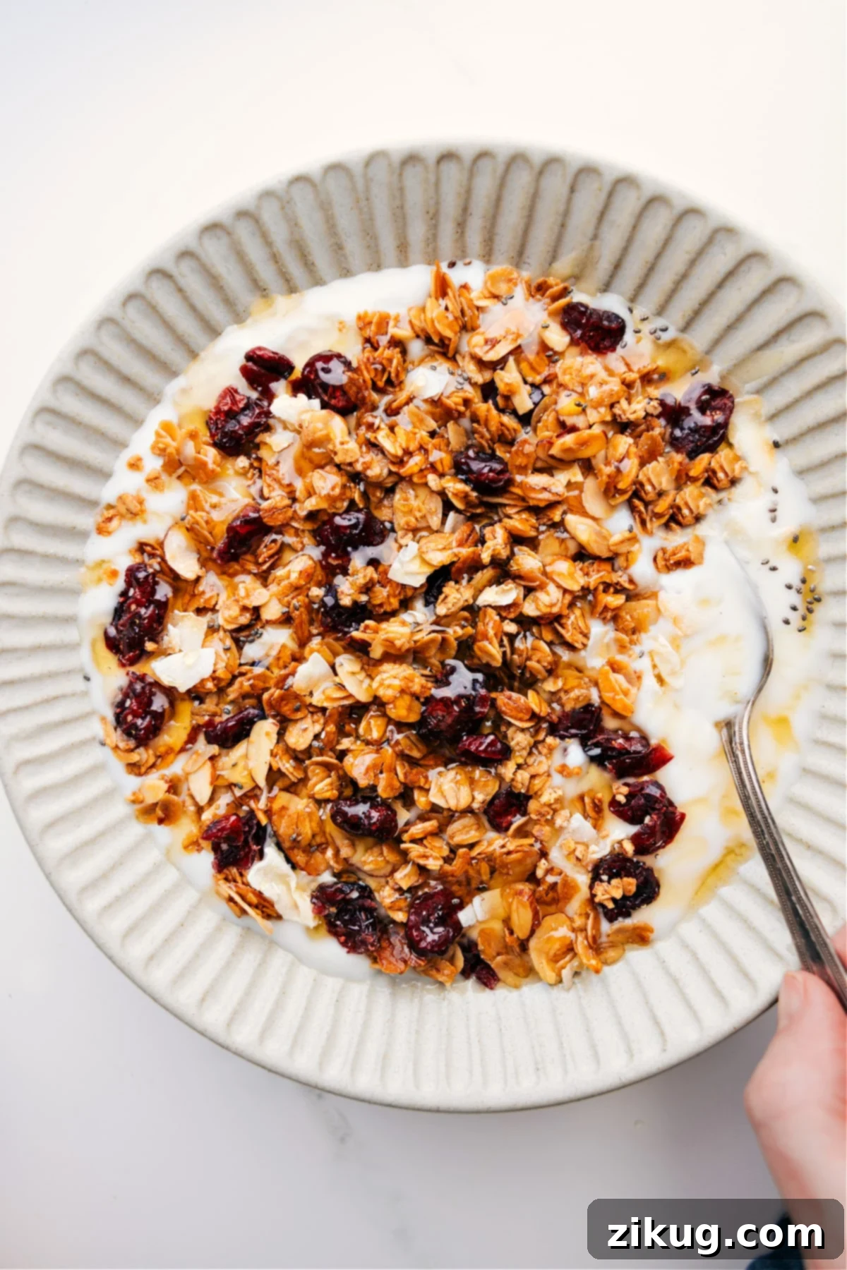 The Perfect Snack: Homemade Honey Almond Granola Honey Almond Granola sprinkled over yogurt with a drizzle of honey on top, accompanied by fresh berries.