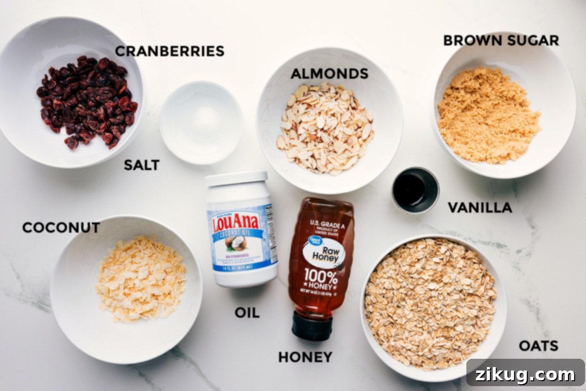Ingredients In Honey Almond Granola Recipe All the ingredients for Honey Almond Granola prepped and ready to assemble: cranberries, salt, almonds, brown sugar, vanilla, oats, honey, oil, and coconut flakes arranged on a wooden board.