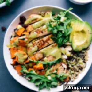 Savory Chicken and Wild Rice Medley 3 Chicken and wild rice in a bowl, featuring well-cooked, sliced chicken and creamy sauce poured on top, creating a healthy and delicious meal.