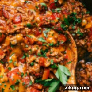 One-Pan Unstuffed Peppers 3 A vibrant pan of Unstuffed Peppers, brimming with seasoned ground meat, colorful bell peppers, and a rich tomato sauce, beautifully topped with fresh herbs.