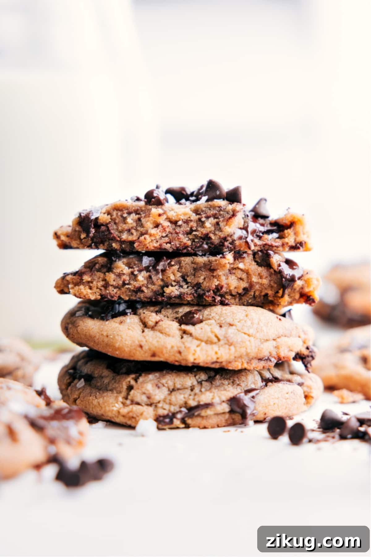 Stacked Small Batch Chocolate Chip Cookies, with one broken open to reveal its soft, gooey, chocolatey center.