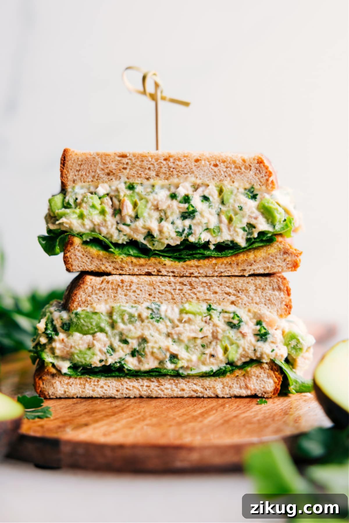 Delectable Avocado Tuna Salad Sandwich for a Healthy Lunch A perfectly assembled Avocado Tuna Salad sandwich, cut in half and stacked, showcasing the creamy avocado filling and fresh ingredients, ready to be enjoyed as a healthy and delicious meal.