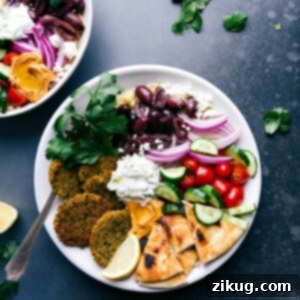 Golden Baked Falafel 3 Baked falafel served on a plate with pita bread, tzatziki sauce, olives, onions, tomatoes, and cucumbers.