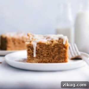 A slice of apple coffee cake on a plate, topped with delicious frosting.