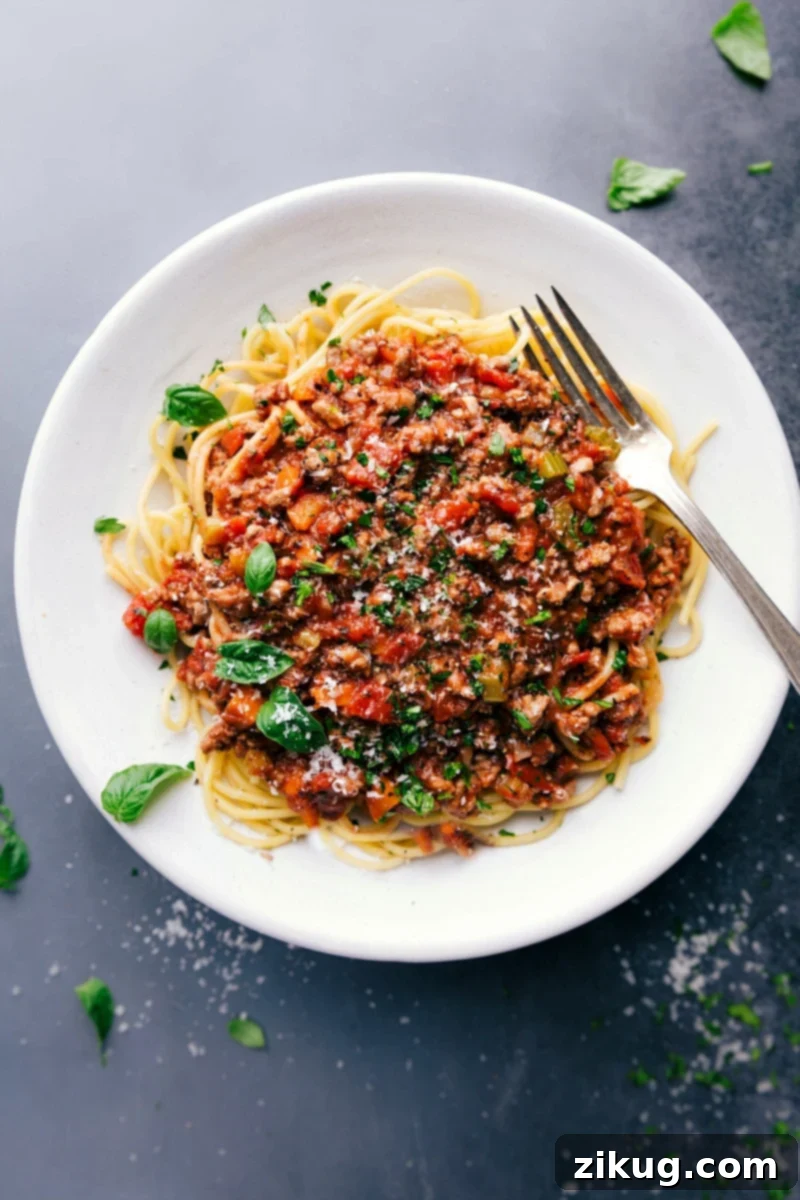 Turkey Bolognese on Spaghetti - Savory Dish with Fresh Herbs Savory and delicious turkey bolognese on a bed of spaghetti, topped with fresh herbs.