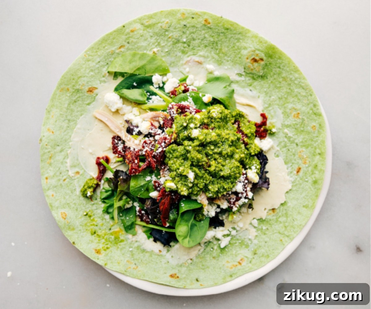 All the delicious ingredients for a Mediterranean Chicken Wrap meticulously assembled inside a tortilla, creating a colorful and appetizing filling ready to be rolled and savored.