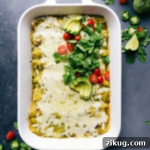 Warm and flavor packed green chile chicken enchiladas in the pan, topped with fresh herbs and tomatoes.