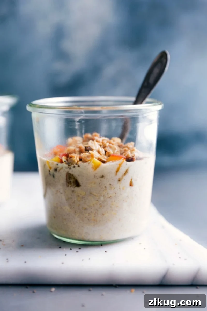 Ready-to-Eat Peach Overnight Oats with Fresh Peach and Granola Toppings A beautifully presented bowl of Peach Cobbler Overnight Oats, adorned with fresh peach slices and a sprinkle of crunchy granola, ready to be savored.