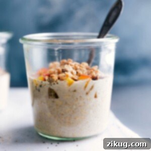 A delectable serving of Peach Cobbler Overnight Oats in a bowl, garnished with fresh peach slices and crunchy granola, ready to be eaten.