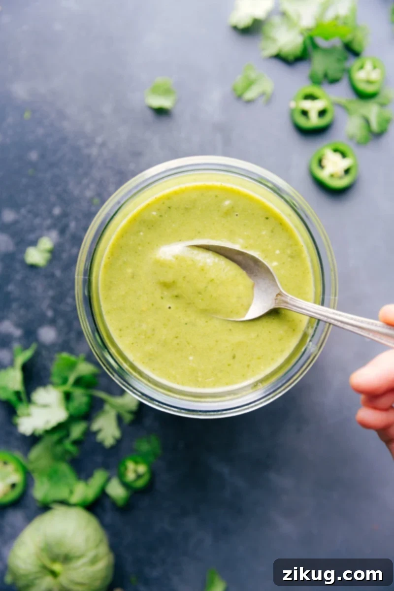 A glass jar filled with vibrant green enchilada sauce, ready to be used or stored.