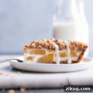 Close-up of a slice of Apple Streusel Pie, showing the layers of crust, apple filling, and streusel topping.