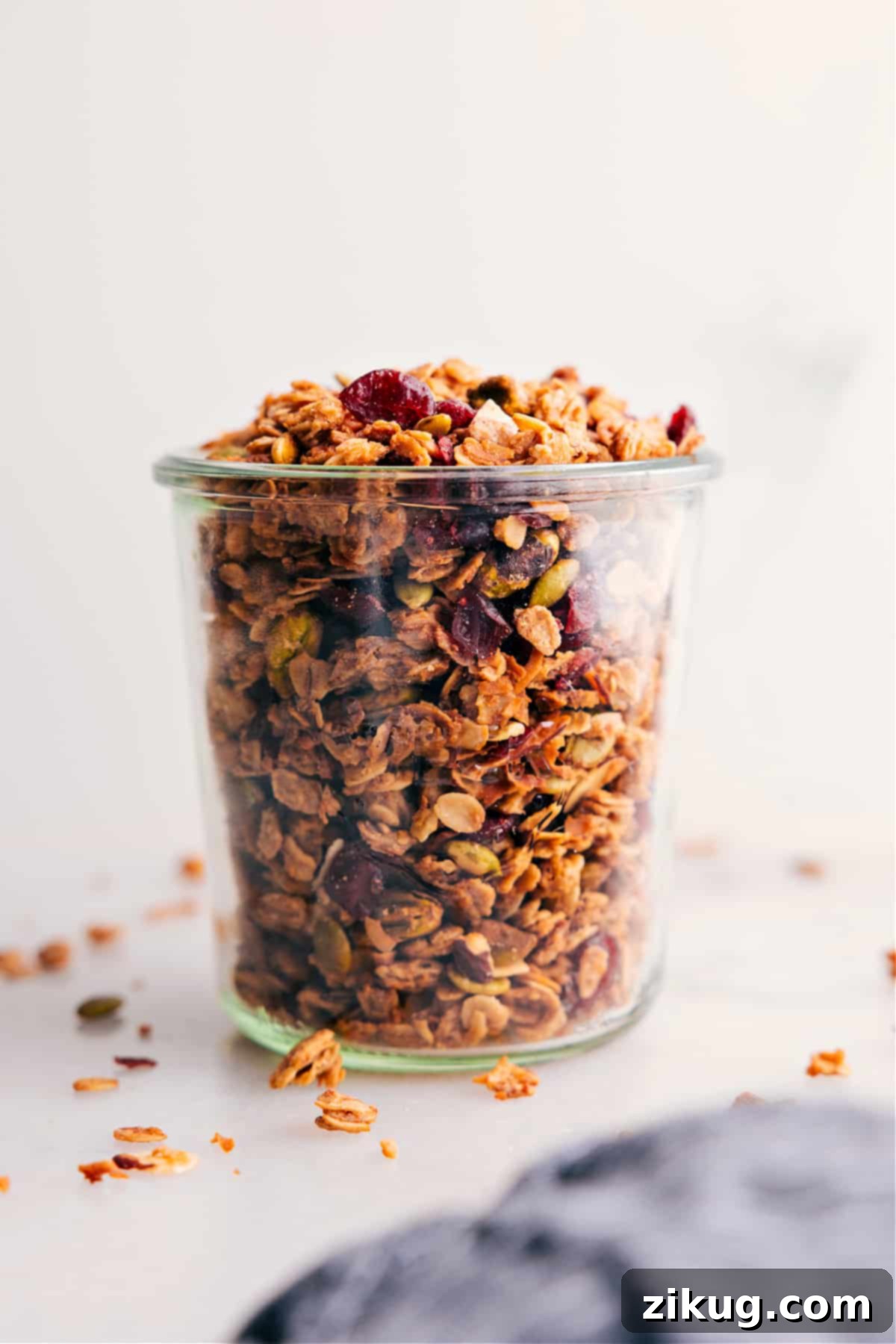 Most Flavorful And Delicious Homemade Granola Recipe Homemade granola neatly packed in a clear glass jar, showcasing its golden color and diverse ingredients, ready to be enjoyed or gifted.