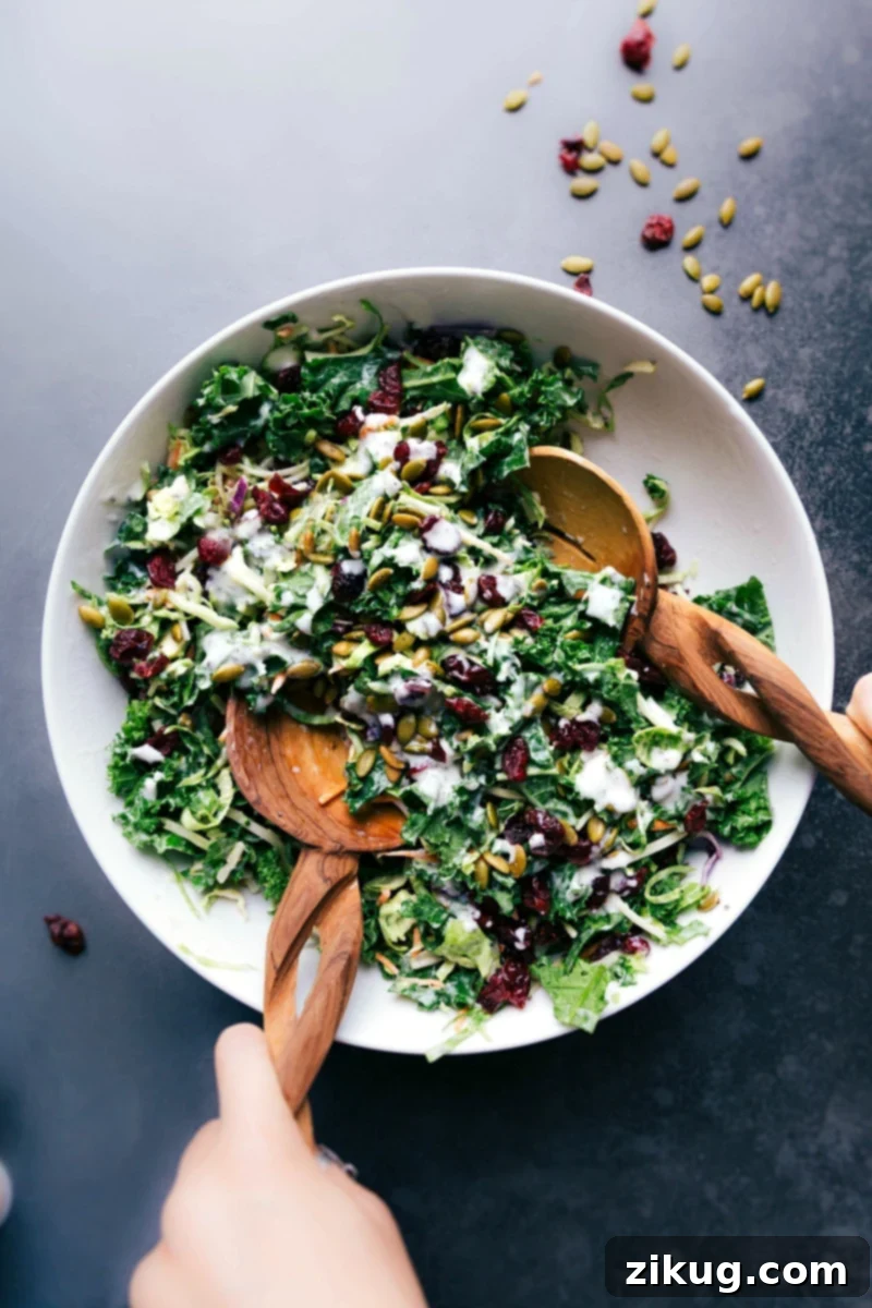 A vibrant bowl of Costco Kale Salad with broccoli slaw, kale, Brussels sprouts, dried cranberries, and pepitas, ready to be served.