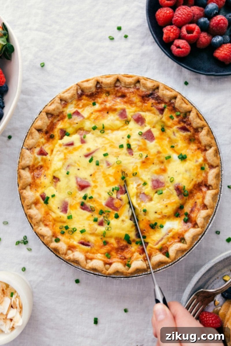 Deliciously Sliced Ham and Cheese Quiche for a Savory Treat Hearty ham and cheese quiche being sliced to serve.