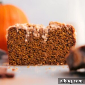 Pumpkin bread with streusel topping, slice removed, showcasing its deliciousness.