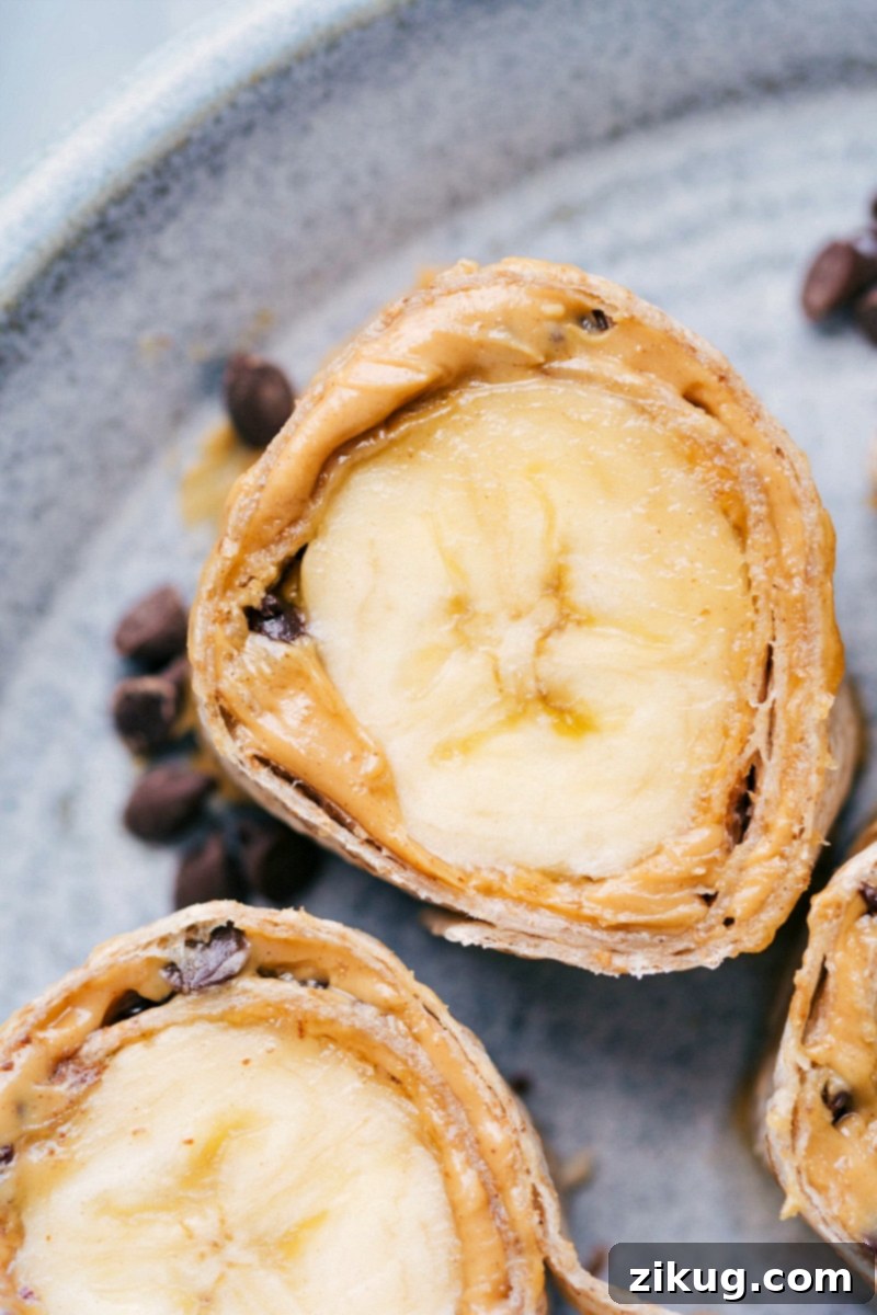 Banana Sushi: A Creative, Healthy, and Fun Snack Idea for All Ages! A cross-section view of colorful banana sushi bites, showcasing the banana, nut butter, and toppings rolled in a tortilla.