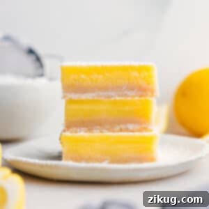 A perfectly baked lemon bar with a dusting of powdered sugar.