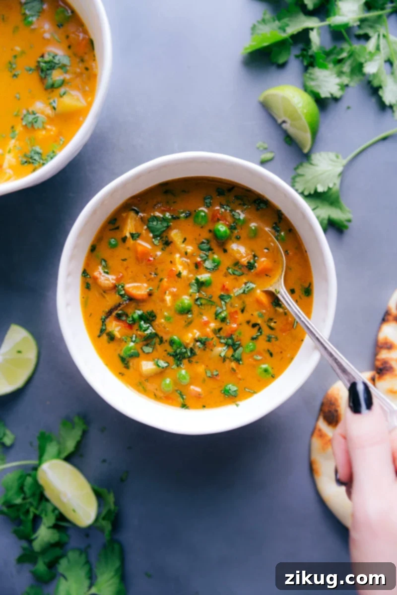 Vibrant and Healthy Chicken Curry Soup Topped with Fresh Herbs, Ready to Be Enjoyed A beautifully presented bowl of vibrant chicken curry soup, generously topped with fresh green herbs, promising a healthy and delicious culinary experience.