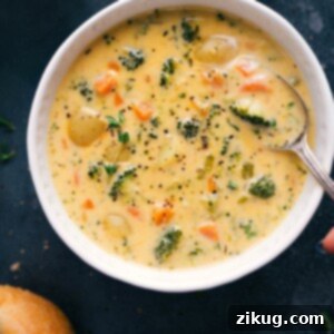 Creamy Potato Broccoli Cheese Soup in a bowl, garnished with chives.