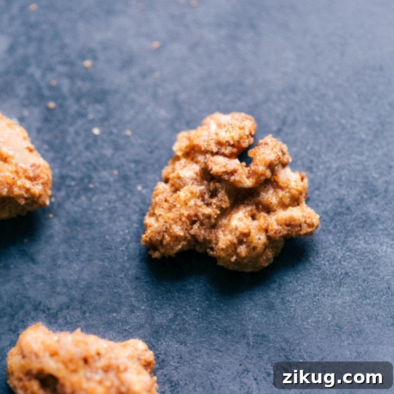 A vivid close-up of candied walnuts, showing their thick, glossy, and caramelized coating and a tempting crunchy texture.