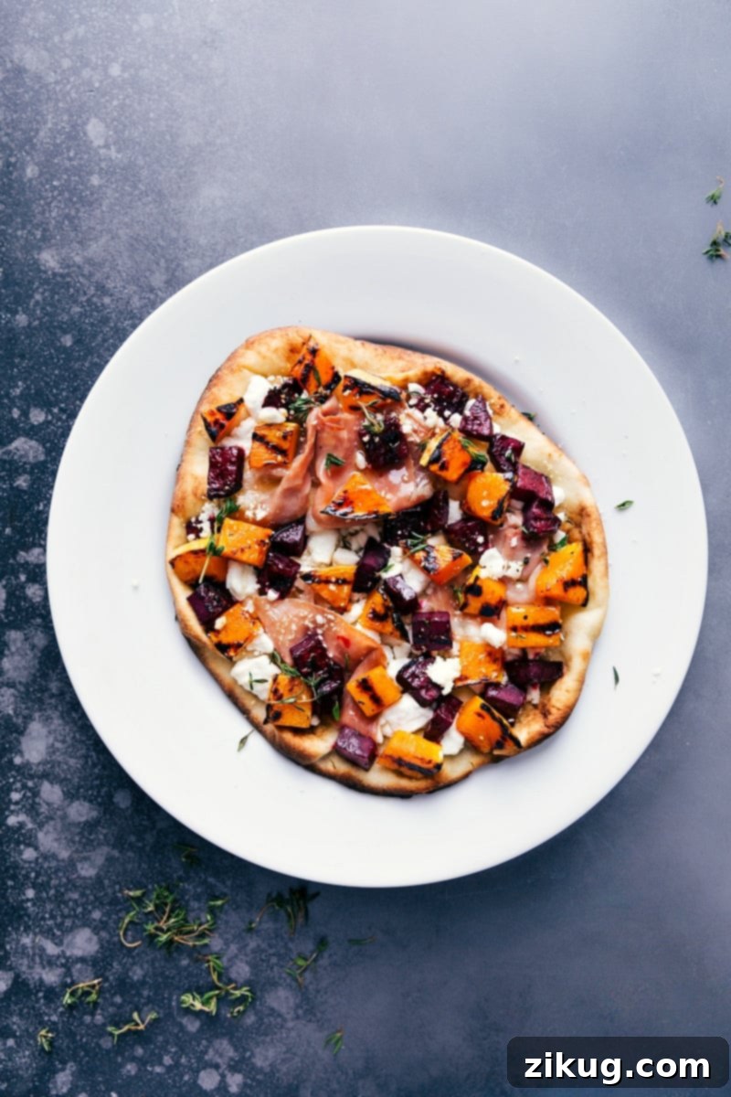 Overhead image of freshly grilled beet and goat cheese flatbread, adorned with vibrant colors and ready to serve as a holiday appetizer.
