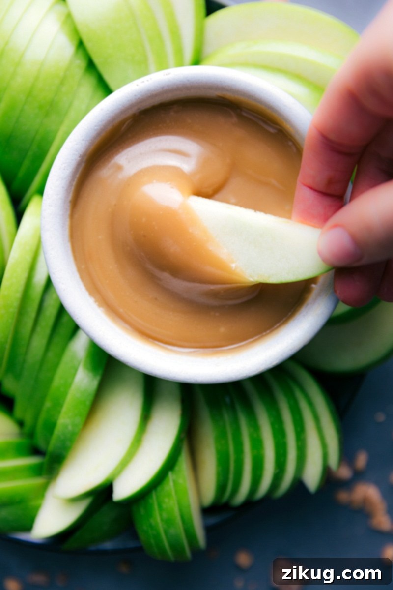 Caramel Sauce with Apple Slice Creamy caramel sauce with an apple slice being dipped in, a perfect combination for a delicious snack.