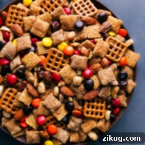 Close-up of a serving of Pumpkin Spice Snack Mix, highlighting its crunchy texture and festive candies.