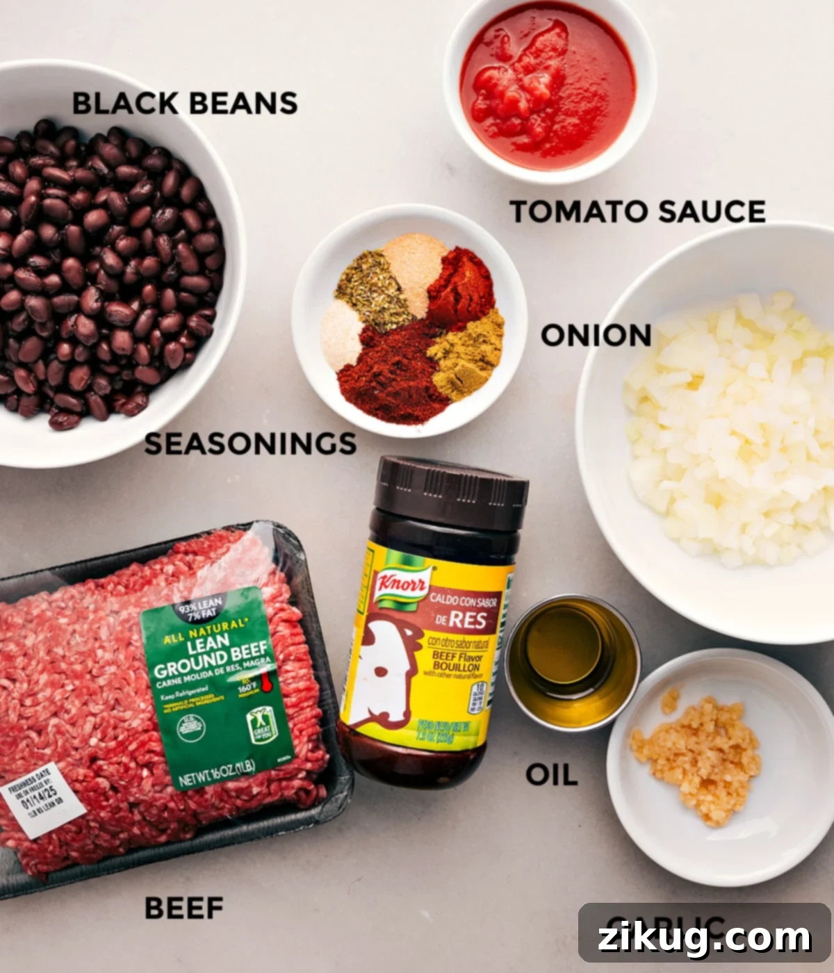 All the ingredients for this recipe are prepped and ready for easy assembly, including tomato sauce, beef, onion, black beans, seasonings, oil, and garlic.