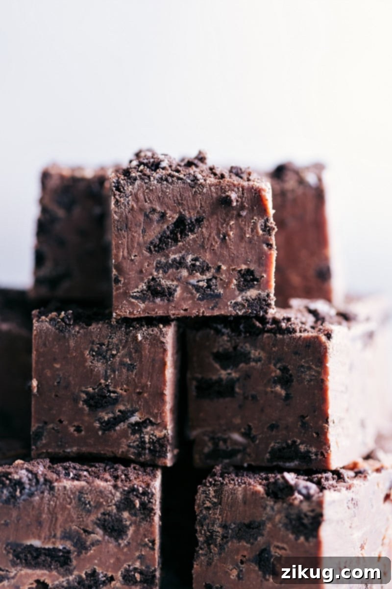 Decadent Oreo Chocolate Fudge 7 Close-up view of multiple pieces of Chocolate-Covered Oreo Fudge, showing the creamy texture and crushed Oreo bits.