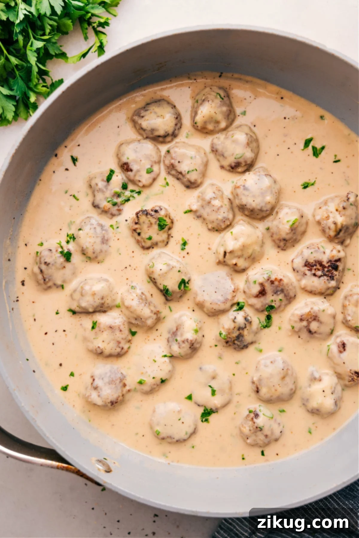 The Best Homemade Swedish Meatballs Recipe Swedish Meatballs simmering in a rich, creamy sauce, garnished with fresh parsley.