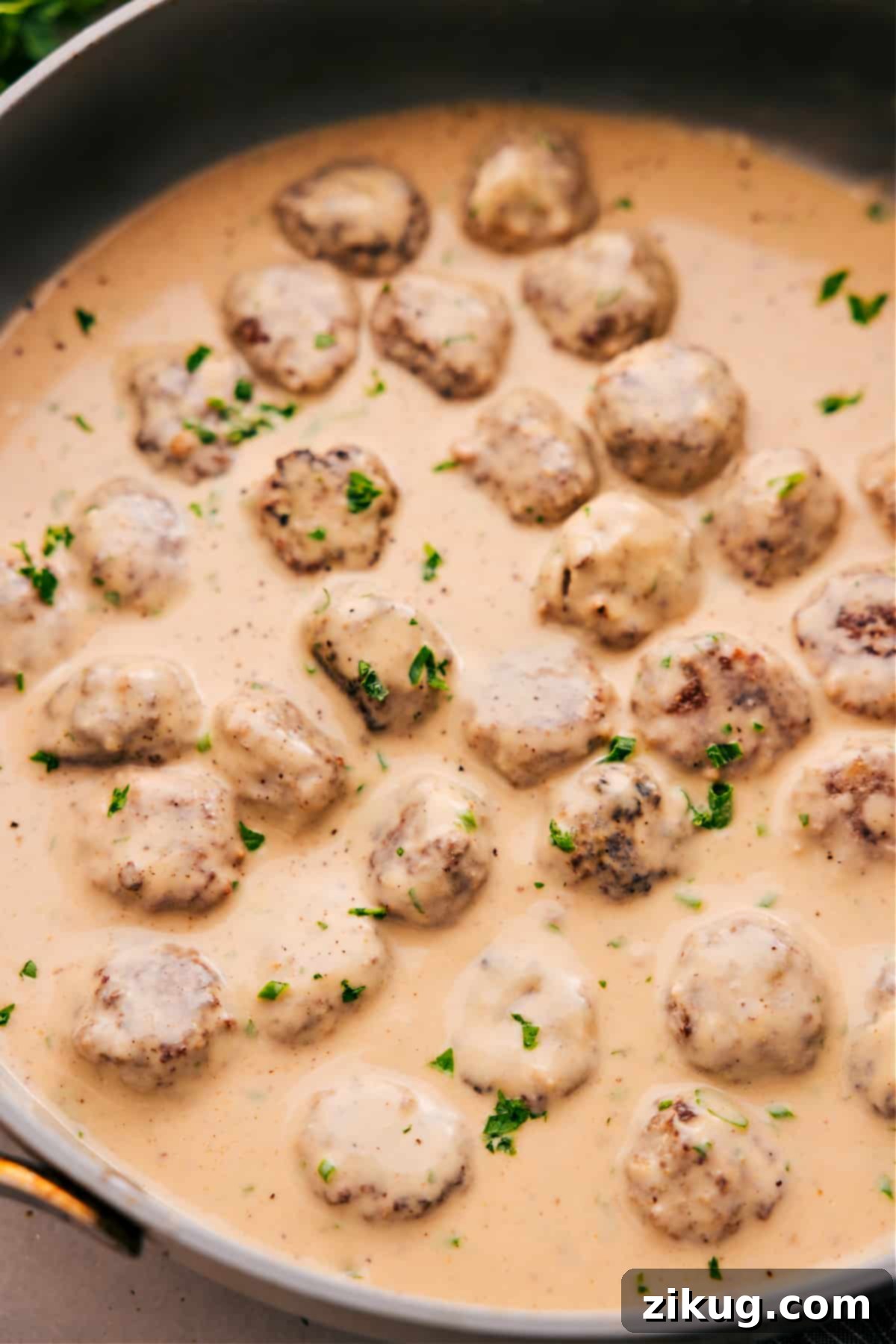 One-Skillet Creamy Swedish Meatballs Delicious Swedish meatballs in a creamy sauce, garnished with fresh chopped parsley, presented beautifully and ready to be served.
