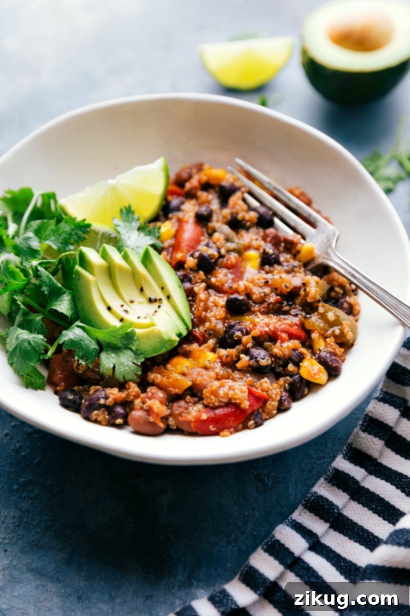 Fajita-inspired flavors make up this delicious and nutritious Crockpot Quinoa dish. Throw everything (uncooked) into a slow cooker and forget about it as the appliance works its magic! Recipe via ChelseasMessyApron #dinner #quick #easy #simple #best #healthy #avocado #cilantro #crockpot #quinoa The completed Crockpot Quinoa dish in a bowl, garnished and ready to be enjoyed.