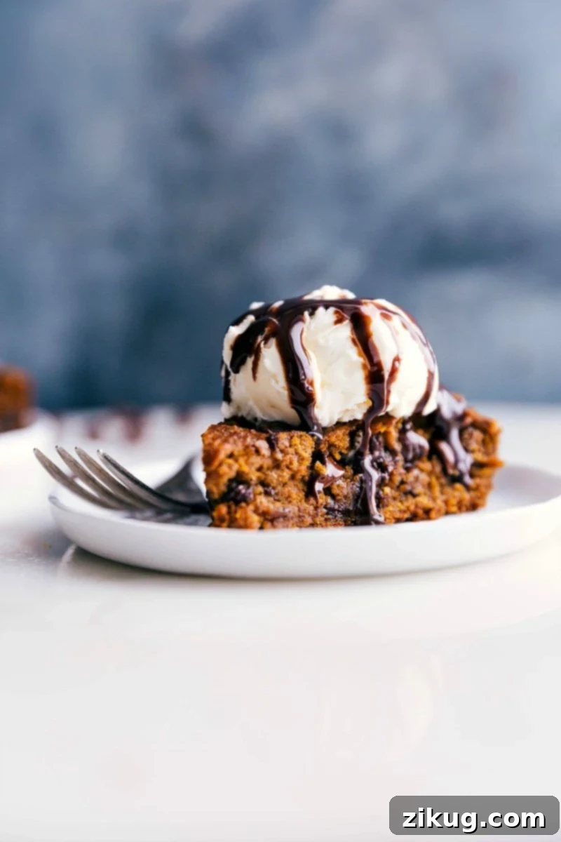 Delectable Gluten-Free Pumpkin Cake with Ice Cream, Ready to Savor A slice of Gluten-Free Pumpkin Cake topped with a generous scoop of vanilla ice cream, ready to be enjoyed.