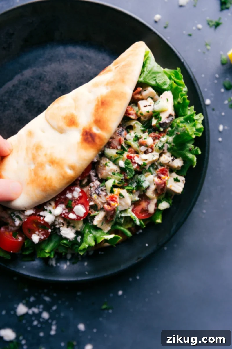 Delicious Greek Chicken Wrap on a plate, showcasing a pita filled with chicken salad, fresh lettuce, and colorful vegetables.