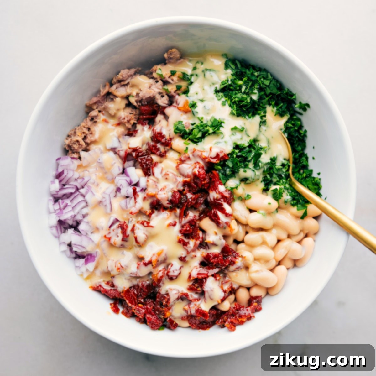 Easy And Delicious Tuna White Bean Salad The freshly prepared Tuna and White Bean Salad, dressed and ready to be tossed together, showcasing its vibrant colors and inviting textures before being served.