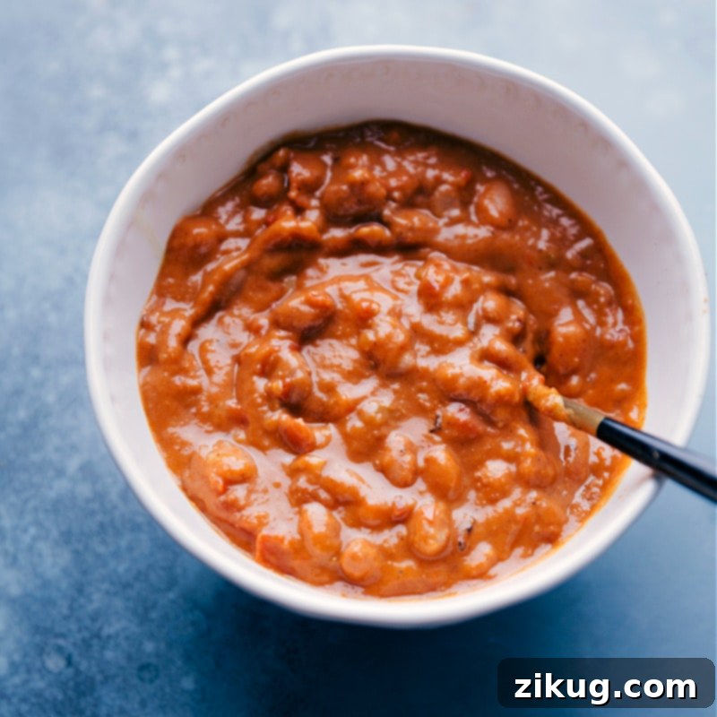 Overhead image of Pinto Beans in a bowl with a spoon in them.