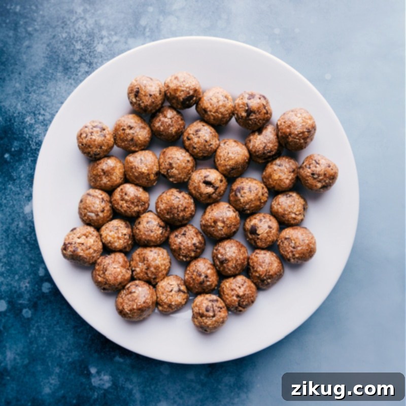 A close-up view of a decorative plate filled with freshly prepared Oatmeal Energy Balls, highlighting their enticing texture and delicious ingredients.