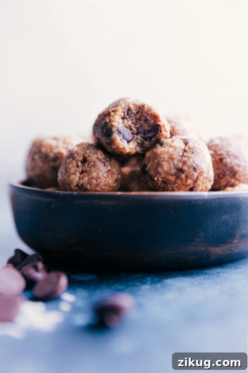 A high-angle view of a glass bowl filled to the brim with tempting Oatmeal Energy Balls, featuring a mix of textures and colors.