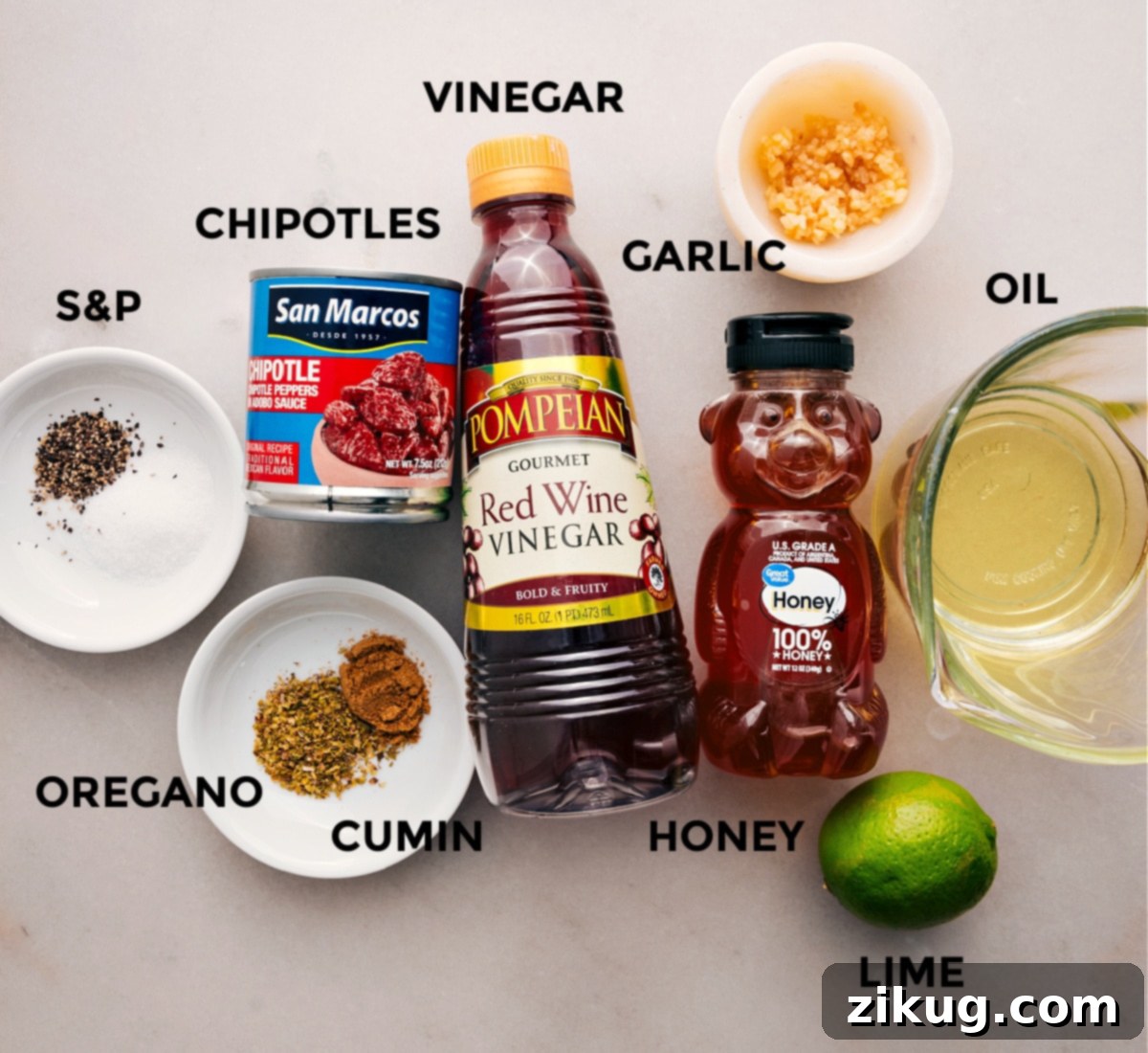 All the vibrant ingredients for the homemade chipotle-lime vinaigrette, including chipotle peppers in adobo, honey, red wine vinegar, vegetable oil, garlic, cumin, oregano, salt, pepper, and fresh lime, neatly arranged for easy preparation.