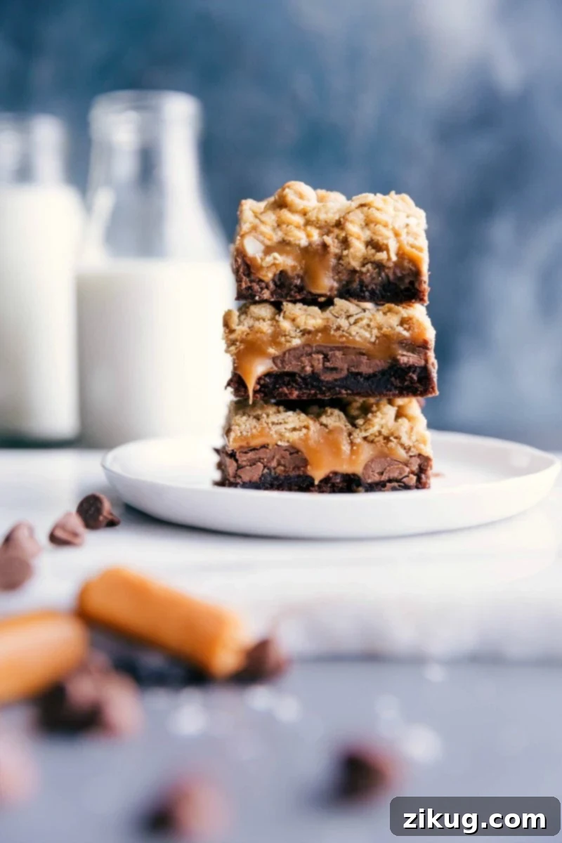 Stacked Brownie Cookie Bars with Oozing Caramel Center, showcasing the fudgy brownie, gooey caramel, and crumbly cookie layers.