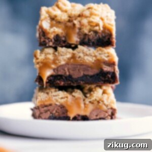 Chocolate chip brownie cookie bars ready to be eaten, with caramel oozing from the center.