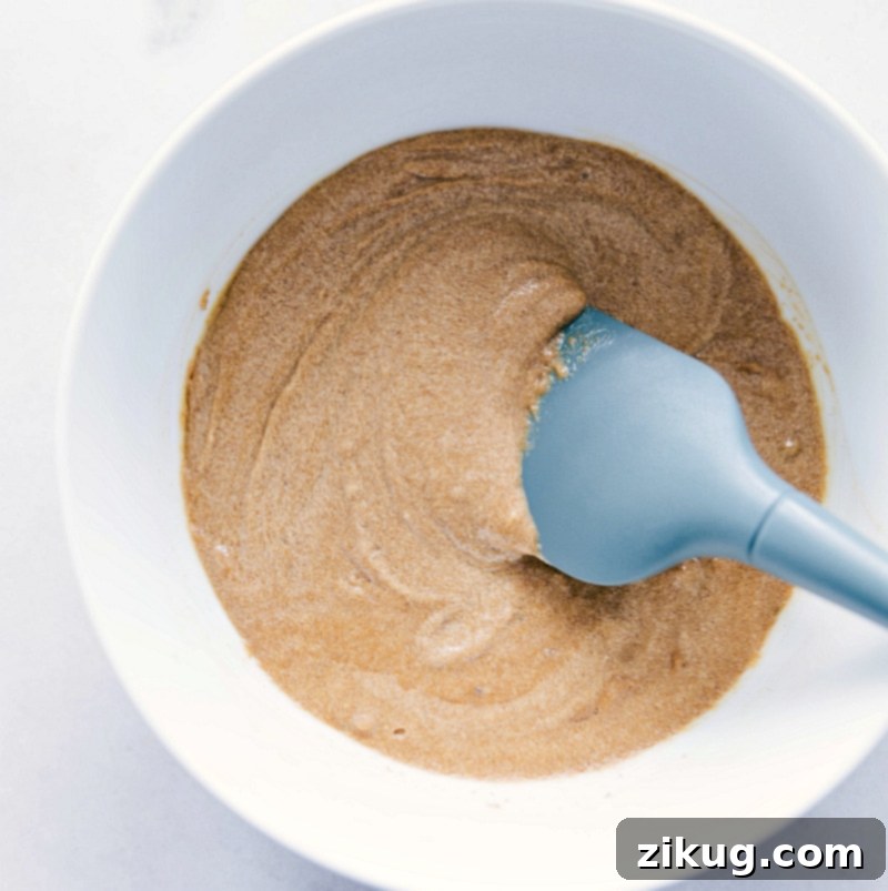 Gluten Free Monster Cookies Ingredients melted and mixed together for this Gluten Free Monster Cookie recipe, creating a smooth, rich dough base, illustrating the initial mixing stage.