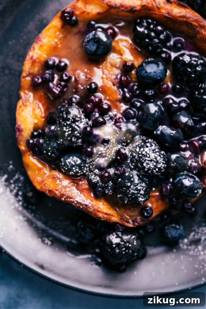 An appetizing overhead view of a freshly made Air Fryer Dutch Baby, beautifully puffed and topped with fresh fruit.